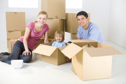 Professional movers carrying furniture through a Harrow property